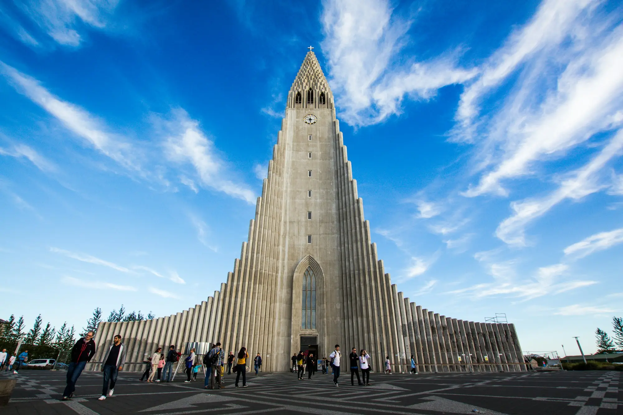 The Hallgrimskirkja church rising over a plaza in Reykjavik, Iceland, under a bright blue sky