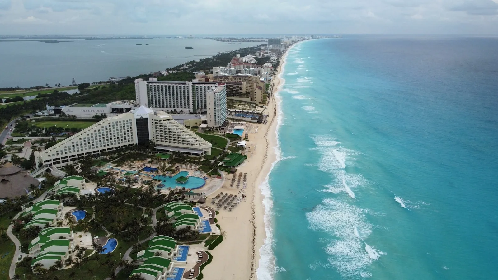 Aerial view of a Cancun Hotel Zone resort and white-sand beach beside turquoise Caribbean water