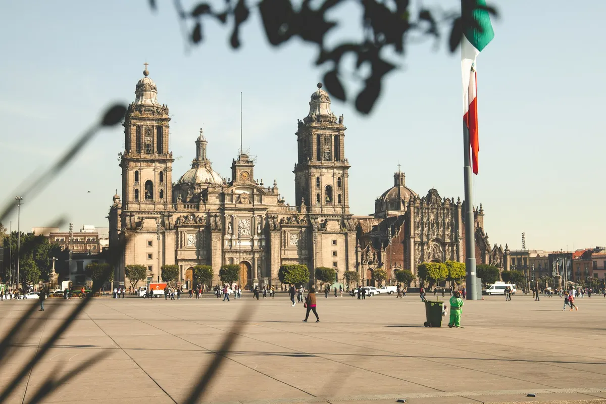 The Metropolitan Cathedral on the Zocalo in central Mexico City, with people crossing the wide plaza in daylight