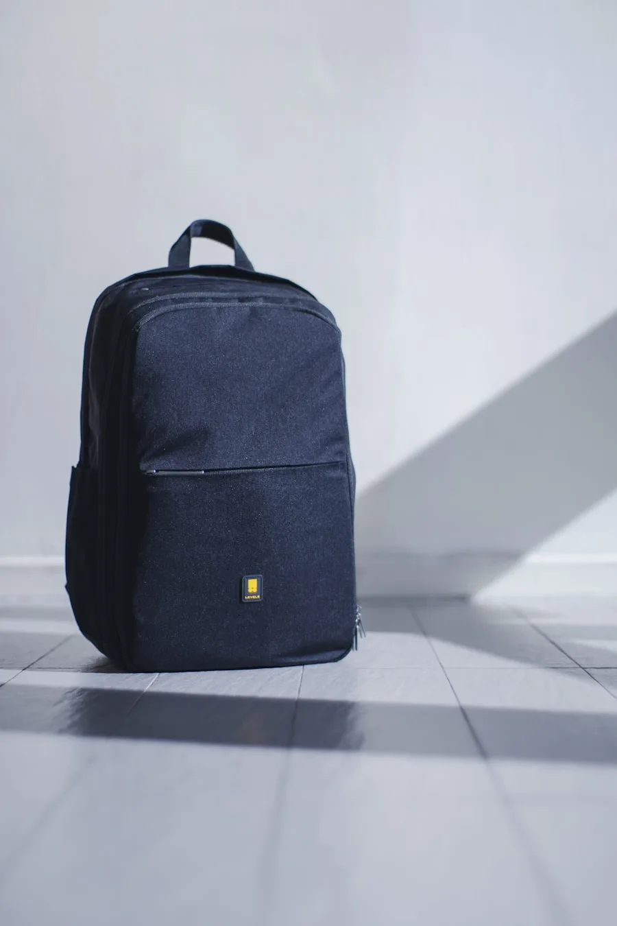 An open carry-on suitcase organized with travel essentials and a hat on top